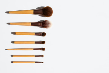 Top view of make up brushes set in a line. Natural tools with bamboo wood handles. Copy space.