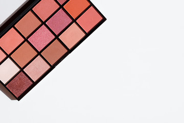 Top view of make up cosmetic - eye shadow palette in pink and red colors. Copy space on white background.