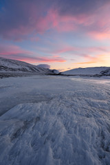 Naklejka na ściany i meble Dramatic sunset over the icy lake in the Arctic tundra. Yamal peninsula.