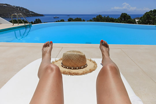 Legs Sunbathing on Lounger Near Swimming Pool. Isolated.