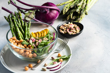 Vegetarian salad, Buddha bowl with asparagus, arugula, zucchini, kohlrabi, pistachio and chickpeas. Selective focus, rustic style