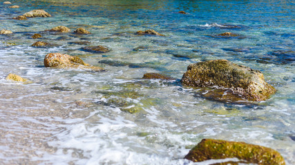 background of transparent sea water and bottom, with stones and waves