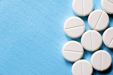 White pills close up on blue background