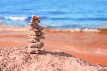 Fototapeta na wymiar Stack of stones at bright colored sea coast