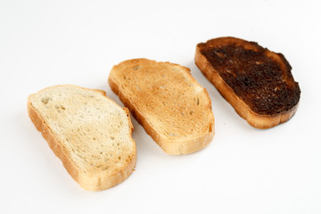 Three toast in different stages of roasting on white background
