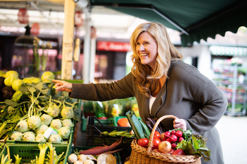 Frau kauft Obst und Gemüse auf dem Markt  - obrazy, fototapety, plakaty