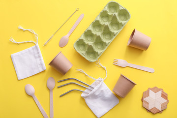 Cups with cutlery, straws and bags on color background. Zero waste concept