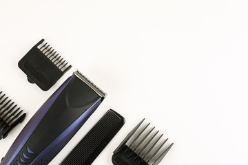Electric hair clipper with different size attachments on a white background, top view, text space