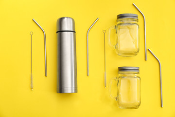 Thermos, glass jars and metal straws on color background. Zero waste concept