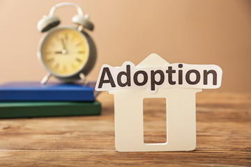 Figure of house and word ADOPTION on table