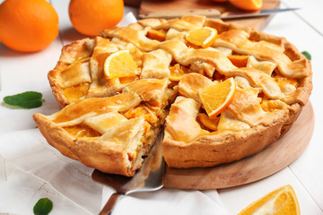 Tasty orange pie on table