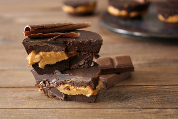Tasty chocolate peanut butter cups on wooden table