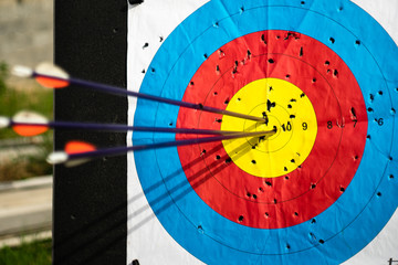 Close up on three arrows in the middle center of the target goal achieved success archery