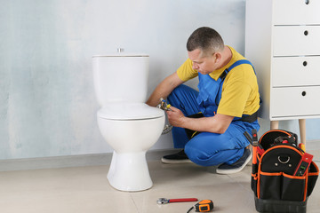 Plumber working in restroom