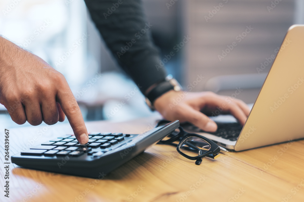 Poster businessman using laptop and calculator