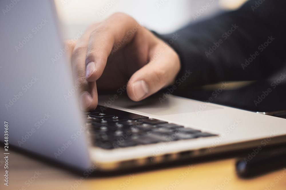 Poster closeup of man using laptop on workspace