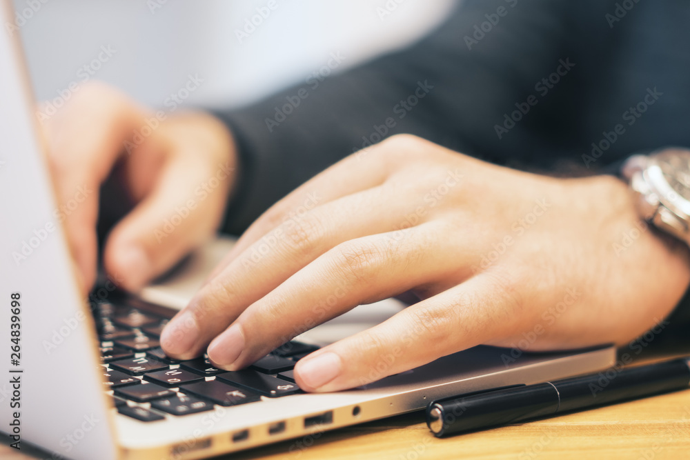 Poster sideview of man using laptop on desk top