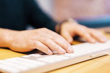 Sideview of male hands using keyboard