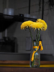 A bouquet of yellow flowers in a dark interior.