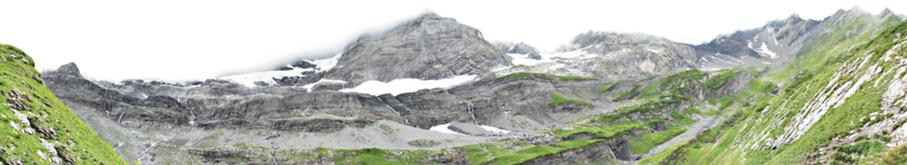 Panorama of mountain scenery with green meadows and snow-capped mountains in the Alps.