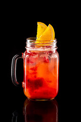 Cold fruit lemonade in mason jar isolated on black