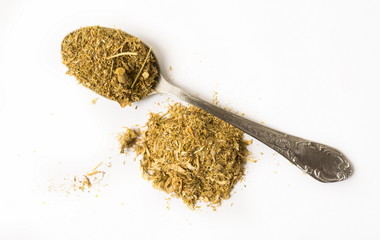 Dry chamomile on spoon on the white