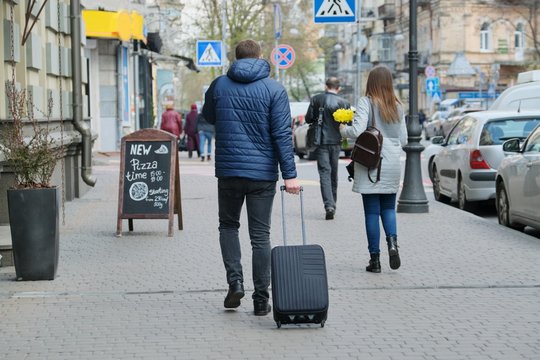 Man In Jacket With Suitcase Walking Down City Street, Back View