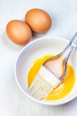 EGGS AND BOWL WITH SHAVE EGG AND KITCHEN BRUSH ON CLEAR WOOD FUND