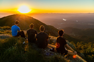 Friends watching sunset on a mountain