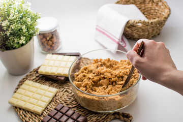 A Woman Making 3 Chocolates cake Pie, Ingredients on the table. Kitchen with white, dark and milk chocolate.