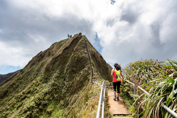 Hiker on a lush a ridge trail on Oahu, Hawaii overlooking Kaneohe, Kailua and the windward side of the island