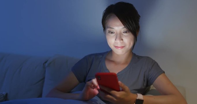 Woman use of smart phone online and sit on the sofa at home