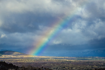 Large rainbow over fields in Spain, rural landscape seen from A1 motorway