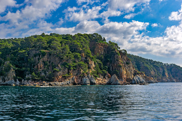 Scenery rocky seascape in spanish Mediterranean sea coast. Scenic rocks in clear turquoise sea water. Blanes, Costa Brava, Spain.
