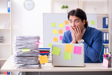 Young male handsome employee in conflicting priorities concept 