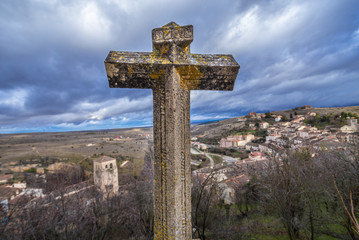 Stone cross in front of Church of Holy Savior in Sepulveda, small historical town in Segovia region of Spain