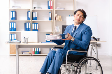 Male employee in wheelchair working at the office 