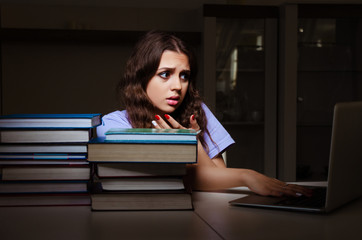 Young female student preparing for exams late at home 