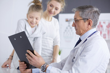Fototapeta premium Little girl with her mother at a doctor on consultation