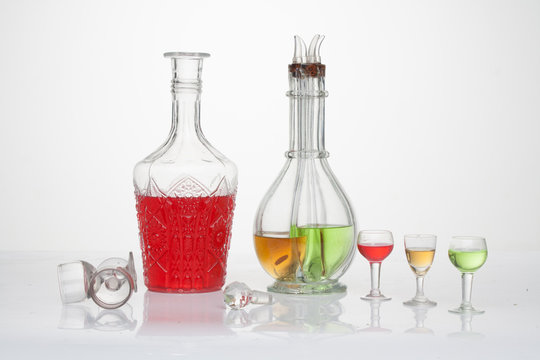 Bodeg&oacute;n de licoreras con copas en fondo blanco