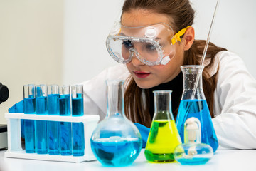 Young woman scientist working in chemical laboratory and examining biochemistry lab sample. Science...