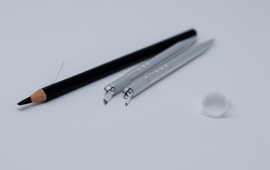 Microblading pens and tools used for applying permanent eyebrow makeup isolated on a white...