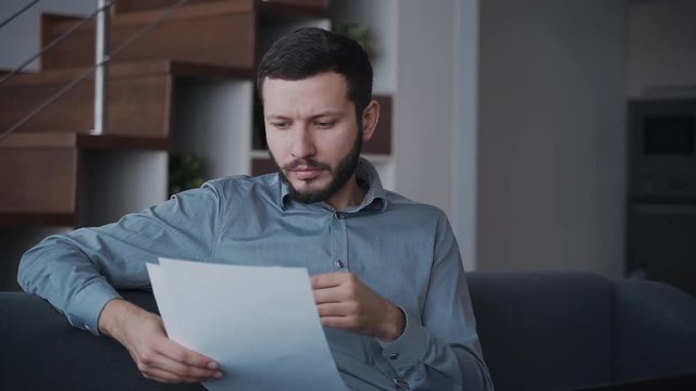 Man reading important working documents and spending time at hom