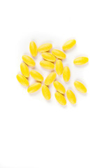 Scattered yellow pills over a white background