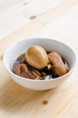 Egg and pork in brown sauce on wooden background, Thai Cuisine