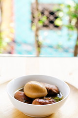 Egg and pork in brown sauce on wooden background, Thai Cuisine