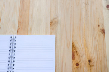 Note book paper on wooden background