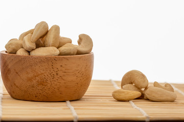 Cashew nuts raw in bowl  on wood with a white background