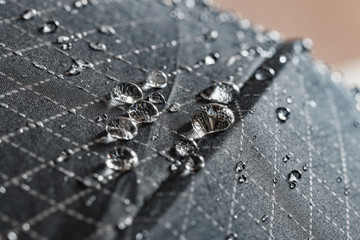 Rain Water droplets on a black waterproof fabric of the umbrella