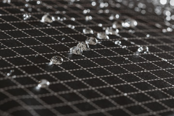 Rain Water droplets on a black waterproof fabric of the umbrella